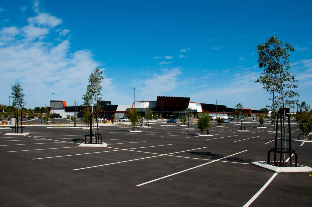 A newly paved, well-marked commercial parking lot with clear signage.