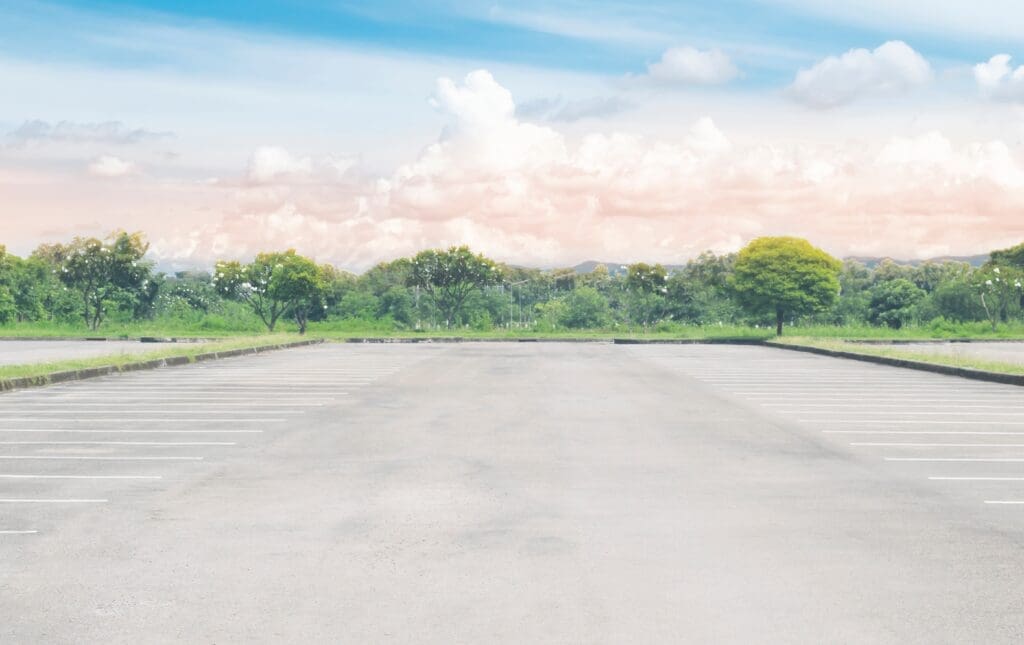 Freshly sealed black asphalt lot with clear Texas sky